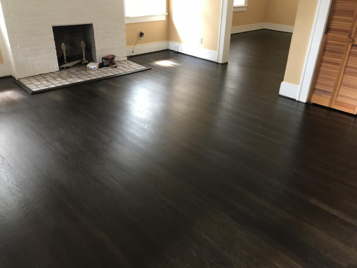 Dark hardwood floor refinishing with fireplace